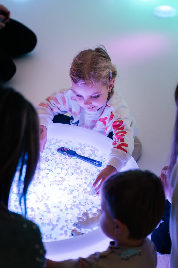 Holčička nad svítícím stolem v sensory roomu