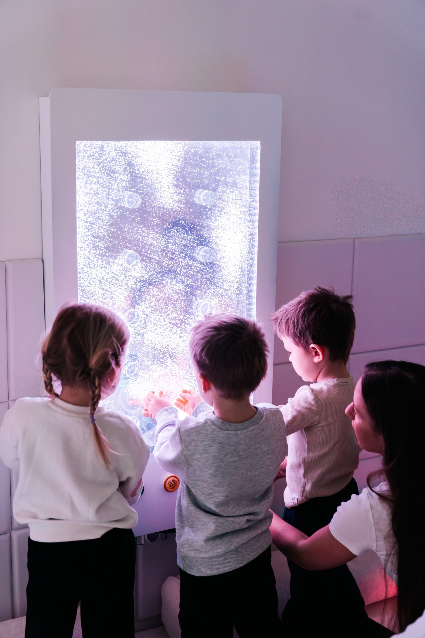 Děti u svítícího bublinkového panelu v sensory roomu